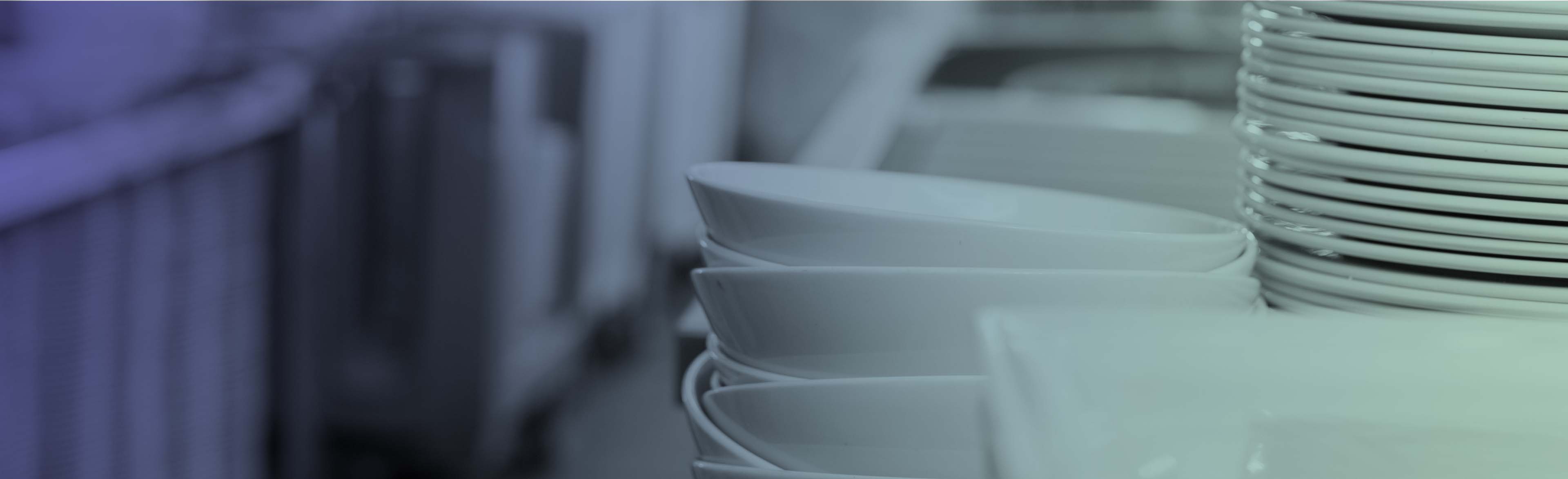 Clean dishes stacked in a commercial kitchen.